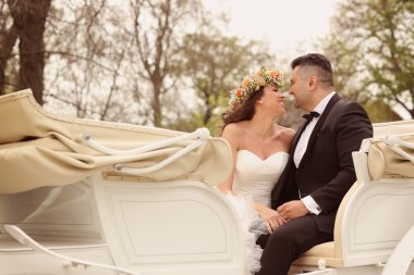 Gelin ve damat beyaz bir at arabası içinde