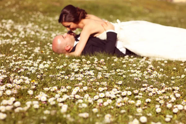 Blommor med bruden och brudgummen som silhuetter — Stockfoto