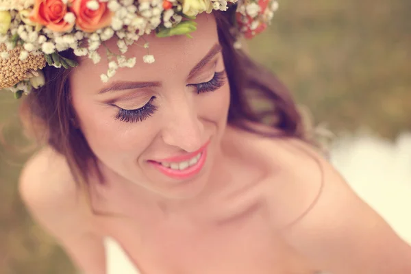 Bela noiva vestindo maquiagem e uma coroa floral — Fotografia de Stock