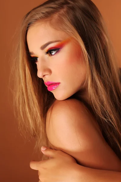 Krásná žena nosí barevné tvoří v ateliéru — Stock fotografie