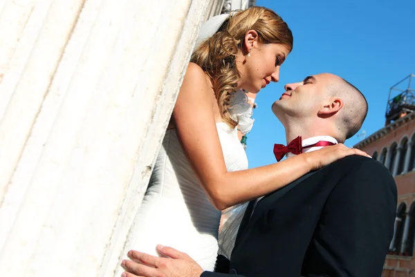 Noiva e noivo beijando na frente da igreja — Fotografia de Stock