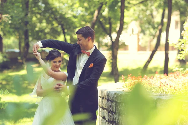 Lyckliga brudparet embracing i park — Stockfoto