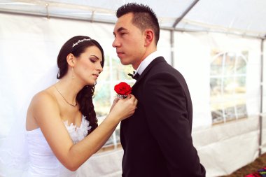 Gül çiçek buketi damat'ın göğsüne koyarak gelin