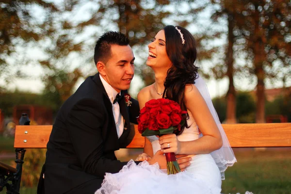 Bruden och brudgummen embracing i park — Stockfoto