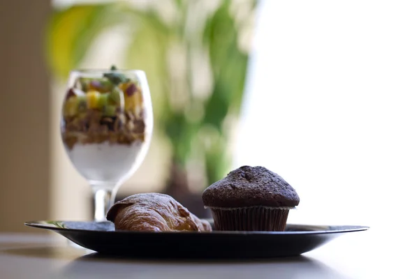 Köstliche Muffins und Croissant mit Früchten und Müslijoghurt — Stockfoto