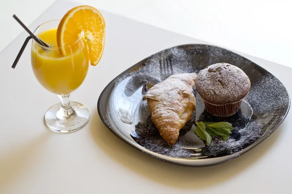 Delicious muffin and croissant with orange juice — Stock Photo, Image