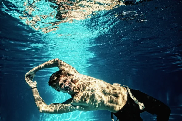 Sexy man duiken in zwembad onderwater — Stockfoto