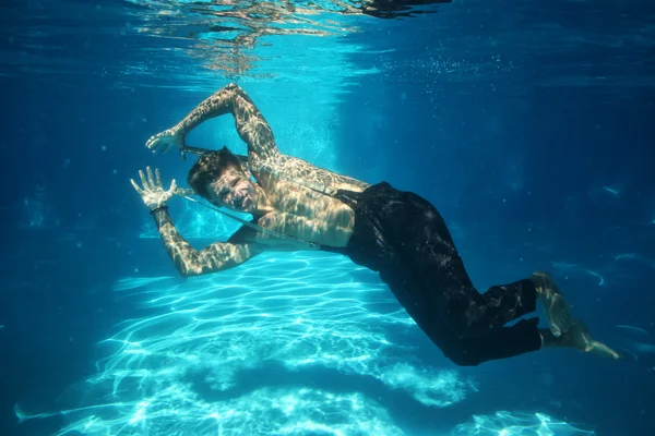 Sexy guy diving in pool underwater — Stock Photo, Image