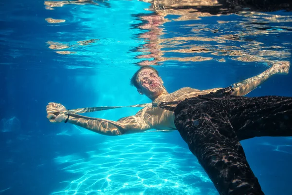 Sexy guy diving in pool underwater — Stock Photo, Image