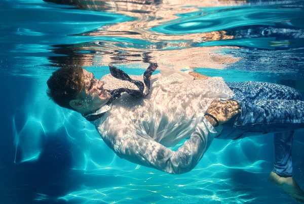 Sexy guy diving in pool underwater — Stock Photo, Image