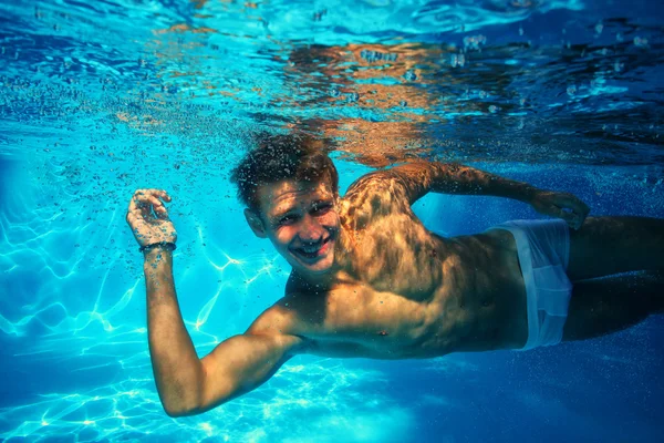 Sexy guy diving in pool underwater — Stock Photo, Image