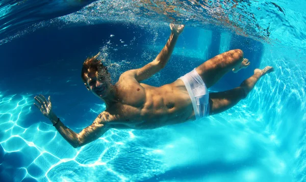 Sexy guy diving in pool underwater — Stock Photo, Image