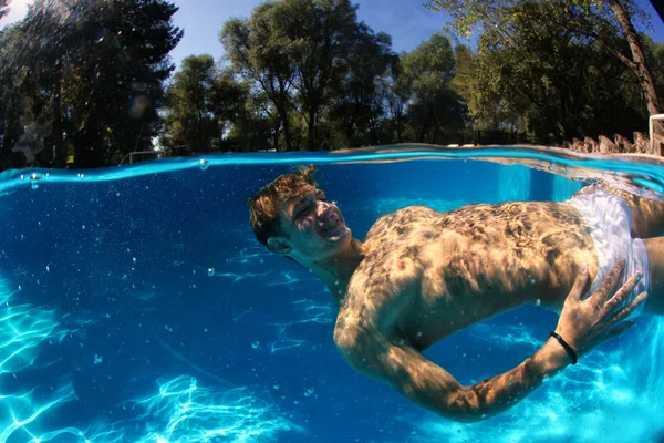 Sexy guy diving in pool underwater — Stock Photo, Image