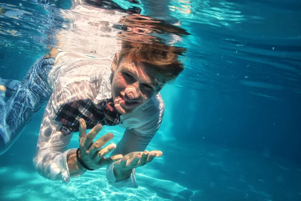 Sexy chlap, potápění v bazénu pod vodou — Stock fotografie