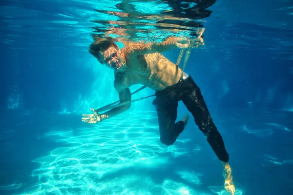 Sexy guy diving in pool underwater — Stock Photo, Image