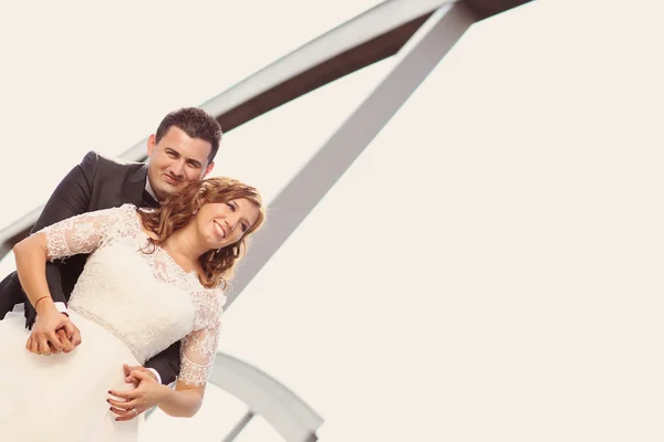 Bruden och brudgummen poserar utomhus — Stockfoto