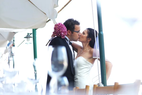 Bruid en bruidegom kussen in de stad — Stockfoto