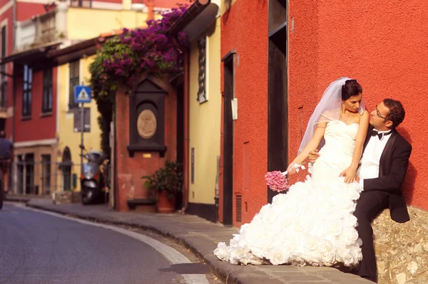 Brudgummen och bruden poserar i staden — Stockfoto