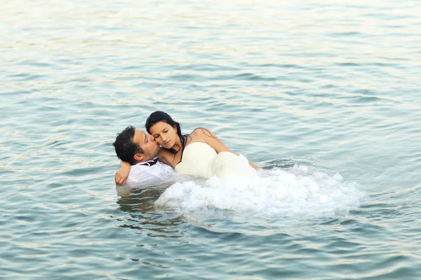 Bruid en bruidegom zwemmen met hun kleren op — Stockfoto