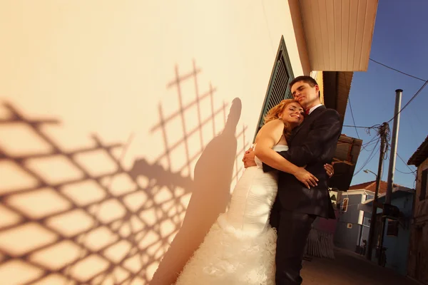 Bruden kysser brudgummen embracing — Stockfoto