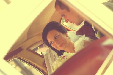 Güzel gelin ve damat arabaya gülümseyen