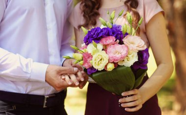 Güzel gelin çift parkta kucaklayan ve buket holding