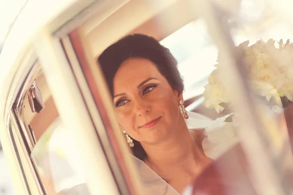 Superbe mariée posant dans la voiture le jour du mariage — Photo