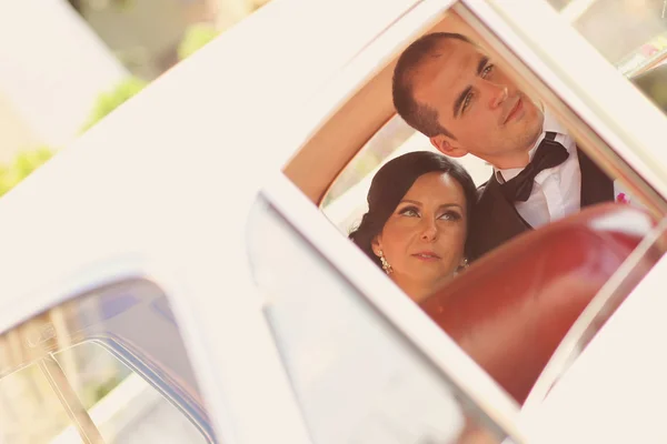 Pengantin wanita dan pria yang cantik tersenyum di mobil — Stok Foto