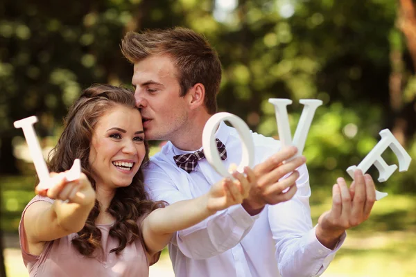 Krásné svatební pár, líbání a drží milostné dopisy — Stock fotografie
