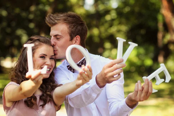 Krásné svatební pár, líbání a drží milostné dopisy — Stock fotografie
