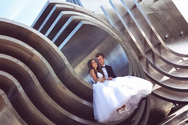 Hermosa pareja nupcial abrazando cerca de la arquitectura —  Fotos de Stock