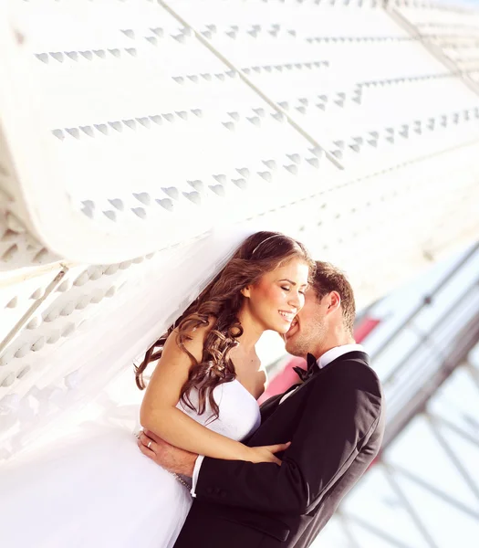 Beautiful bridal couple embracing near architecture — Stock Photo, Image