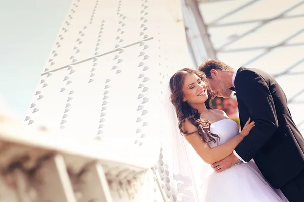 Beautiful bridal couple embracing near architecture — Stock Photo, Image