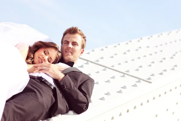 Belo casal nupcial abraçando perto da arquitetura — Fotografia de Stock