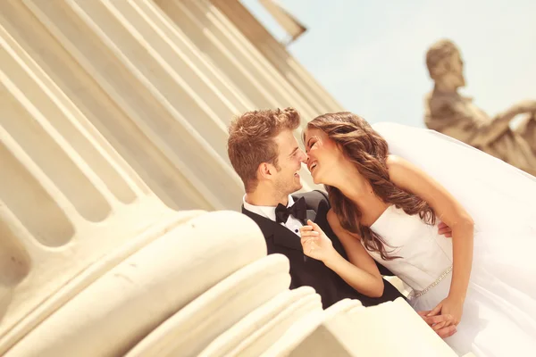 Bella coppia di sposi che abbraccia vicino a colonne — Foto Stock