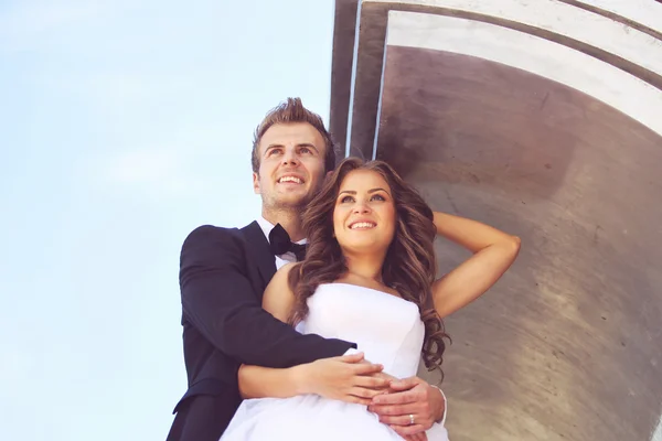 Bella coppia di sposi abbracciando vicino all'architettura — Foto Stock
