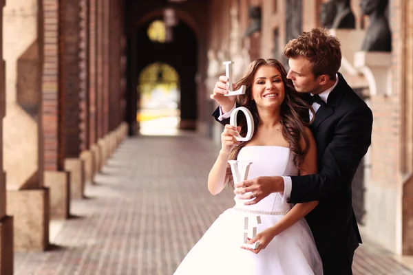 Mooie bruid en bruidegom omarmen in de stad — Stockfoto