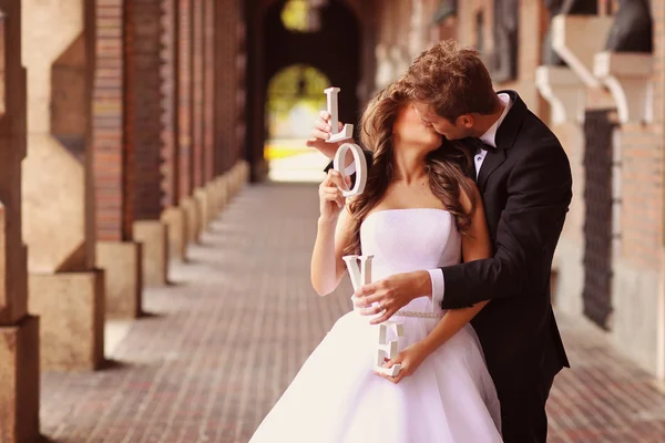 Krásná nevěsta a ženich všeobjímající ve městě — Stock fotografie