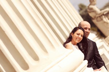 Güzel gelin ve damat sütunları kucaklayan