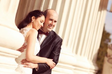Güzel gelin ve damat sütunları kucaklayan