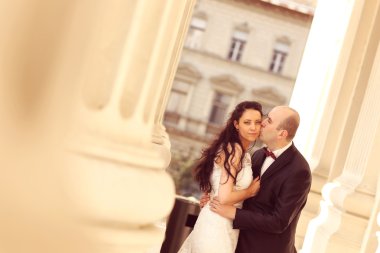 Güzel gelin ve damat sütunları kucaklayan