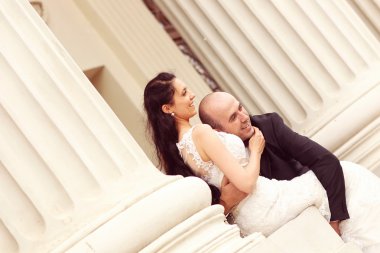 Güzel gelin ve damat sütunları kucaklayan