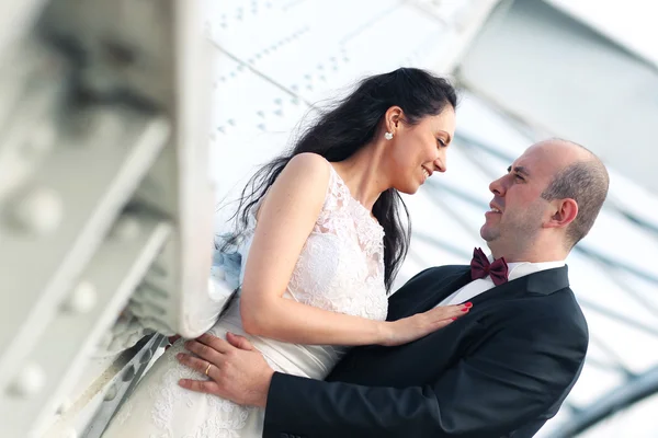 Beautiful bride and groom embracing in the city — Stock Photo, Image