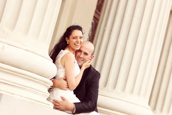 Hermosa novia y novio abrazando cerca de columnas —  Fotos de Stock
