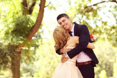 Güzel gelin ve damat parkta kucaklayan