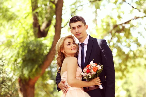 Hermosa novia y novio abrazándose en el parque — Foto de Stock