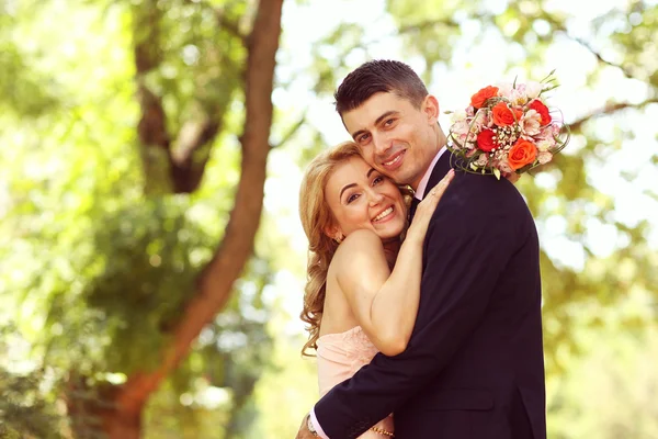 Hermosa novia y novio abrazándose en el parque —  Fotos de Stock