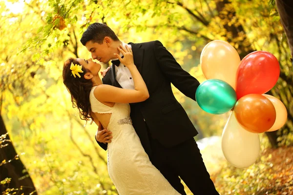 Vackra bruden och brudgummen embracing i skogen — Stockfoto