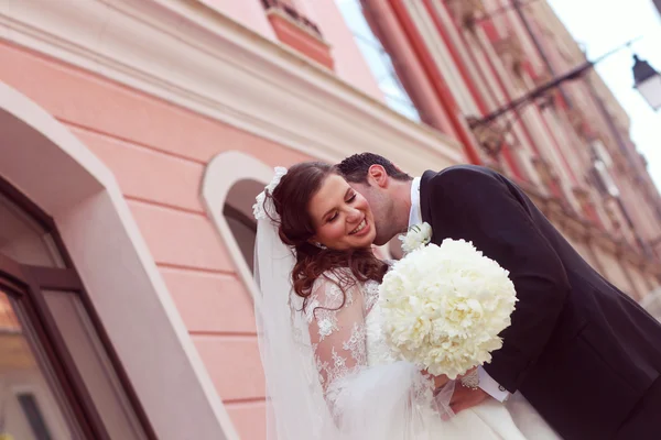 Beautiful bride and groom embracing in city — Stock Photo, Image