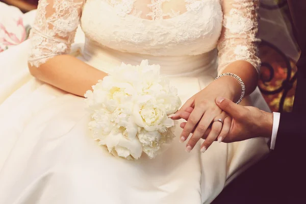 Mãos de casal nupcial segurando belo buquê — Fotografia de Stock